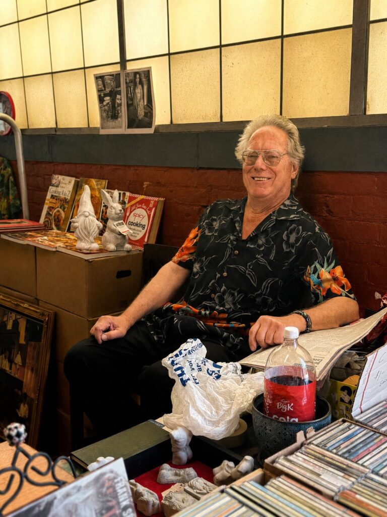 Royal Oak Antiques Market: The People Behind a Sunday Tradition 4 Alvin seated at his vendor booth inside the Royal Oak Antiques Market